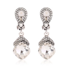 Detailed view of silver drop earrings featuring pavé rhinestones and faceted clear crystals