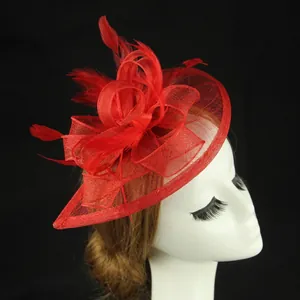 Close-up of bright red bridal fascinator with mesh bow and elegant feathers