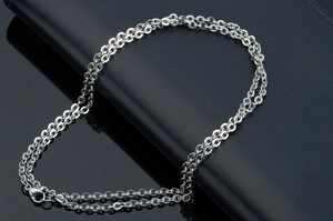Detailed close-up of a silver stainless steel hammer cross chain showing circular links