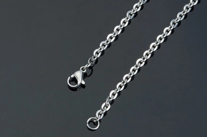 Detail of silver stainless steel cross chain with secure lobster clasp and tail ring