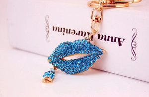 Detail of blue rhinestone lips keychain with lipstick charm and gold lobster clasp