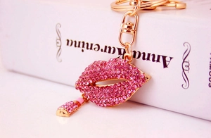 Close-up of sparkling pink rhinestone red lips keychain with a gold mini lipstick charm