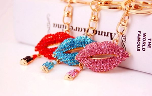 Close-up of sparkling rhinestone lip keychain with lipstick charm and gold metal ring