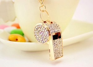 Close-up of golden whistle keychain with sparkling rhinestones and metal ring