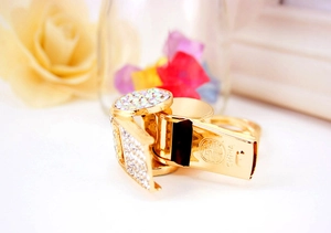 Macro shot of gold whistle keychain with rhinestone accents on soft floral background