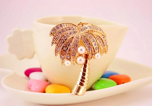 Close-up of coconut tree keychain with sparkling rhinestones and white pearls details