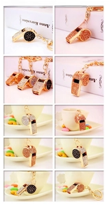 Detailed view of colorful rhinestone-encrusted whistle keychains in various metallic finishes