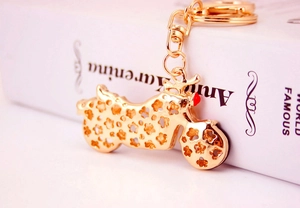 Detailed close-up of golden motorcycle keychain with rhinestone accents and hollowed patterns