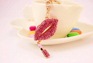 Close-up of sparkling pink rhinestone red lips keychain with small lipstick pendant accessory