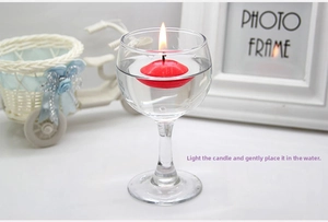 Red floating tea light candle burning in a glass of water for romantic decoration