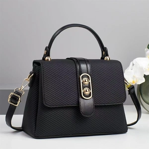 Sac trapèze noir classique en toile texturée avec anneaux dorés et bandoulière