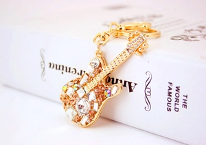 Detailed view of a golden guitar keychain with sparkling inlaid rhinestones and lobster clasp