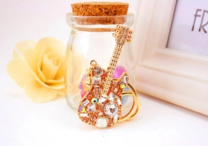 Detailed close-up of golden guitar keychain with sparkling rhinestones and metal ring