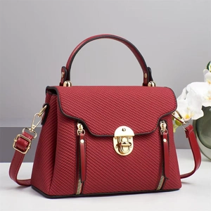 Elegant dark red satchel handbag with twill texture, golden hardware and top handle