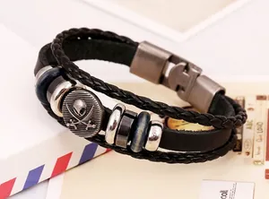 Detail of multi-layer leather bracelet featuring a silver skull and crossed swords charm