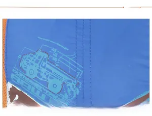 Detail of blue fabric kid's hat featuring truck print and orange mesh stitching