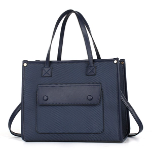 Detailed view of dark blue tote bag showing textile texture and synthetic leather stitching
