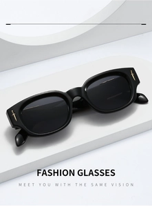 Detail of black rectangular sunglasses with golden dagger ornament on the frame corner