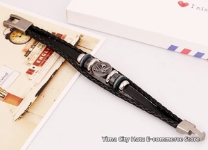 Detail of punk leather bracelet with vintage silver skull charm and braided straps