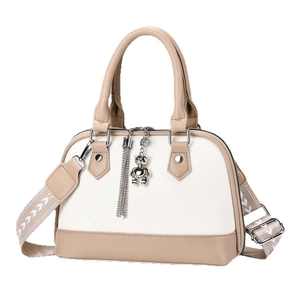Elegant two-tone shell-shaped handbag for women featuring a teddy bear charm and wide strap