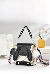 Détail du sac bandoulière avec rabat en cuir noir, design oreilles de lapin et sangle