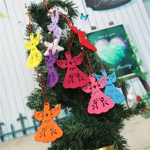 Detail of colorful angel-shaped felt Christmas tree ornaments hanging on branches