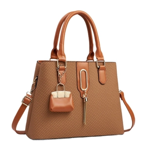 Sac à main marron tissé avec poignées en cuir et breloque à gland pour femme élégante