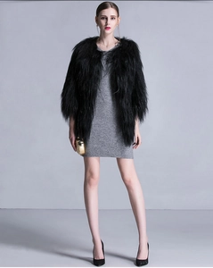 Full view of women's long black faux fur coat styled with a gray bodycon dress