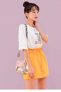 Détail du sac bandoulière rose et beige avec oreilles de lapin et rivets cloutés