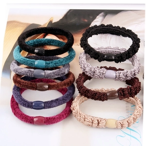 Detail of velvet and braided ponytail holders with elegant matte textures and buckles