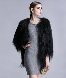 Close-up of elegant black faux fur shawl worn over a grey knit dress in studio light