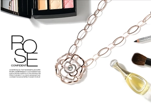 Detailed view of rose gold hollow camellia pendant with zircon inlay on jewelry chain