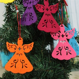 Close-up of a red felt angel ornament with cutout details hanging on a Christmas tree
