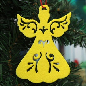 Detail of yellow felt angel Christmas ornament with cutout design on a green tree branch