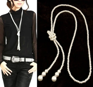 Detail of multi-layer pearl necklace featuring a woven knot and elegant dangling tassels