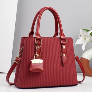 Elegant red textured handbag with gold hardware and detachable strap for summer style