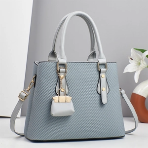 Elegant structured light blue handbag with lattice texture and mini bag charm accessory