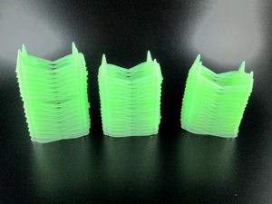 Macro detail of bulk glowing green vampire teeth toys stacked for party supplies