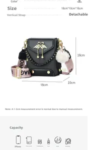 Detailed view of black textured crossbody bag with swan hardware and pink wide strap