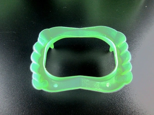 Detail of green plastic glow-in-the-dark vampire teeth props for Halloween party