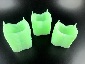 Glow-in-the-dark green vampire teeth props for Halloween party displayed on dark surface