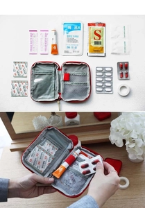 Macro view of portable red medical bag showing transparent pockets and mesh organizers