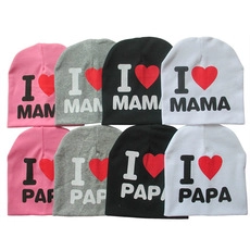 Detail display of baby knit beanies in pink, grey, black, and white with heart patterns