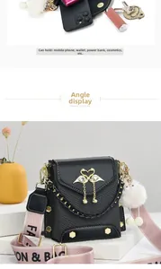 Detail of black woven shoulder bag with golden swan logo and pearl tassel pendant