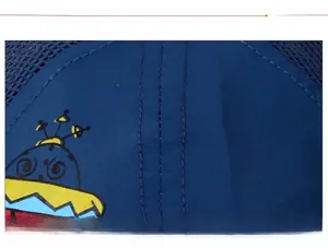 Detail of dark blue kids baseball cap showing fine stitching and colorful UFO print