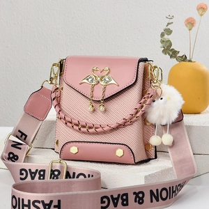 Pink crossbody bag with heart swan ornament and plush charm on white stone background