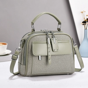 Minimalist sage green canvas handbag with silver rivets and adjustable shoulder strap