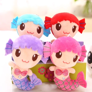 Close-up of four colorful plush mermaid toys with shiny diamond buttons and embroidery