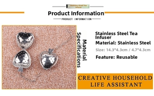 Detailed view of heart-shaped stainless steel tea infuser with chain on plush fabric