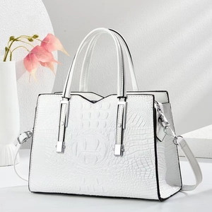 Detail of white crocodile texture handbag with silver hardware and chic top handle